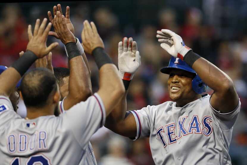 Texas Rangers'  Adrian Beltre, right, is congratulated by teammate Rougned Odor (12) after...