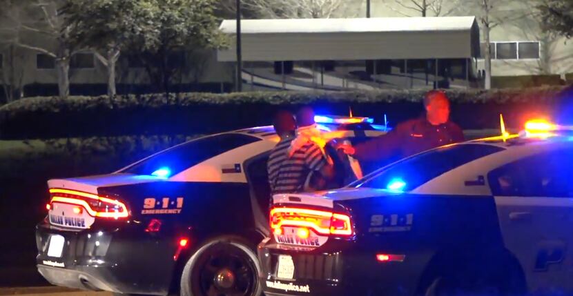 A Red Bird man and his 3-year-old son get inside a police car after an accidental shooting...