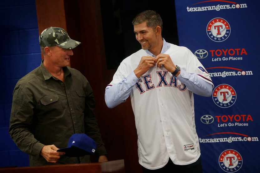 Newly signed Texas Rangers pitcher Mike Minor puts on a Rangers jersey next to Texas Rangers...