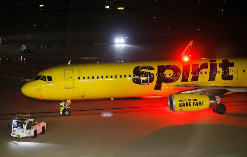 Ground crew workers ready a Spirit Airlines jet for takeoff at DFW International Airport,...
