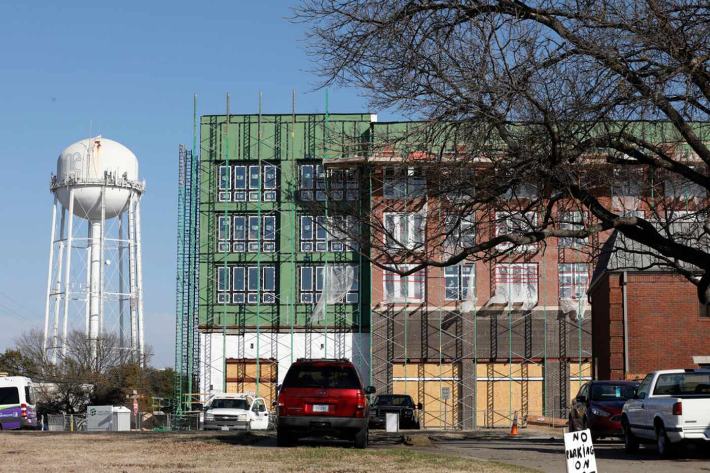 An old McKinney water tower emerges behind new construction in downtown McKinney on...