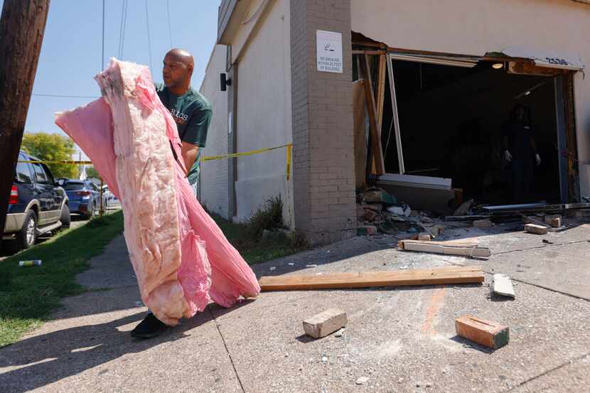 Dexter Allen with Brothers in Christ Services takes debris out of Blackjack Pizza after a...