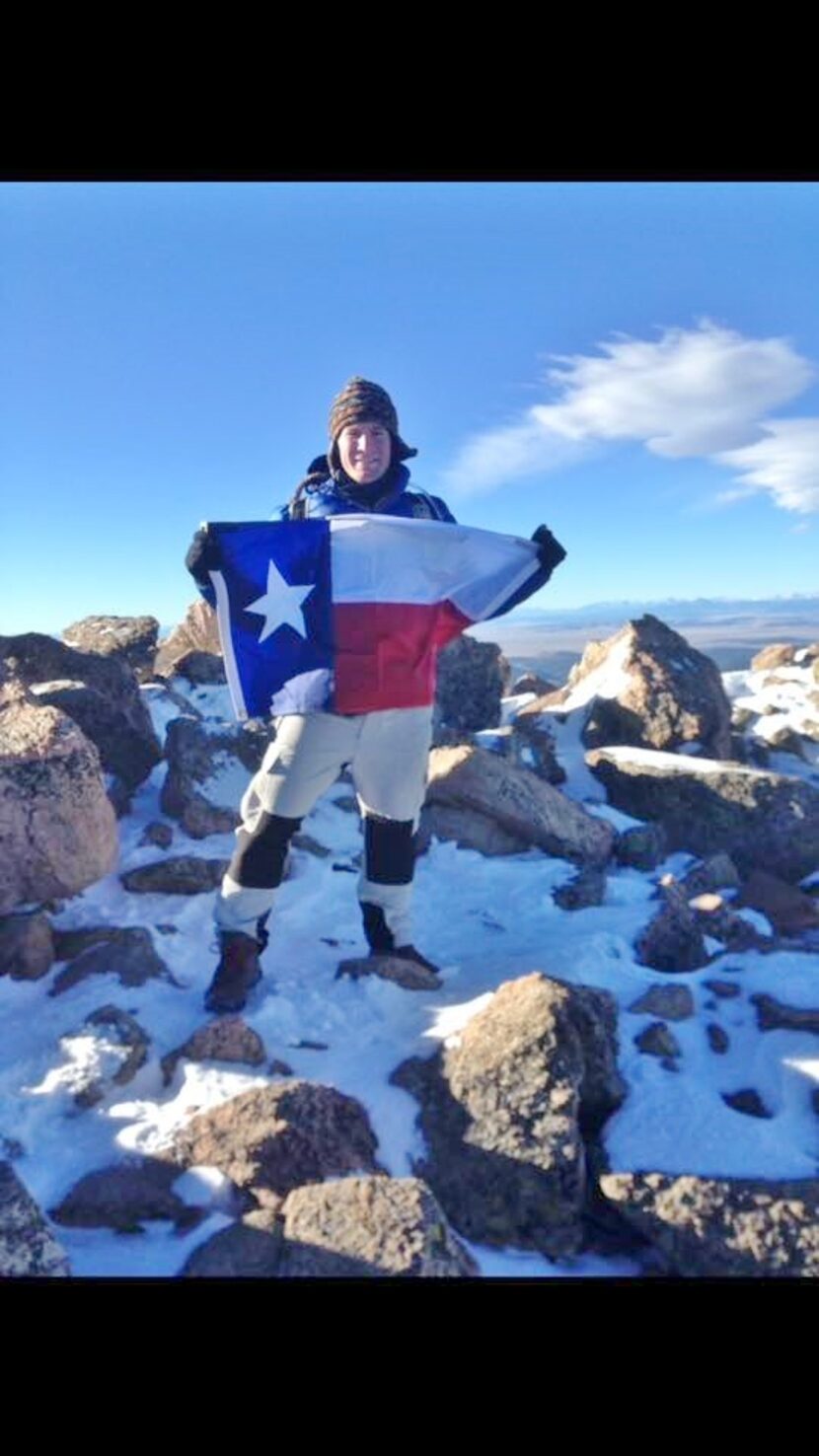 
Hayden Wilson, 21, originally from Preston Hollow, holds a Texas flag Oct. 4 at the peak of...