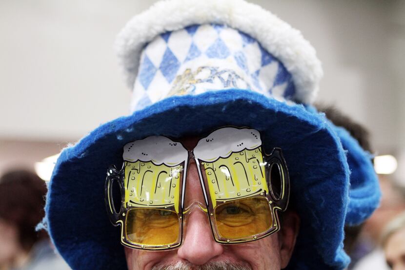 John Keller, 50, of Dallas, sports a beer mug hat and glasses as he waits with friends to...
