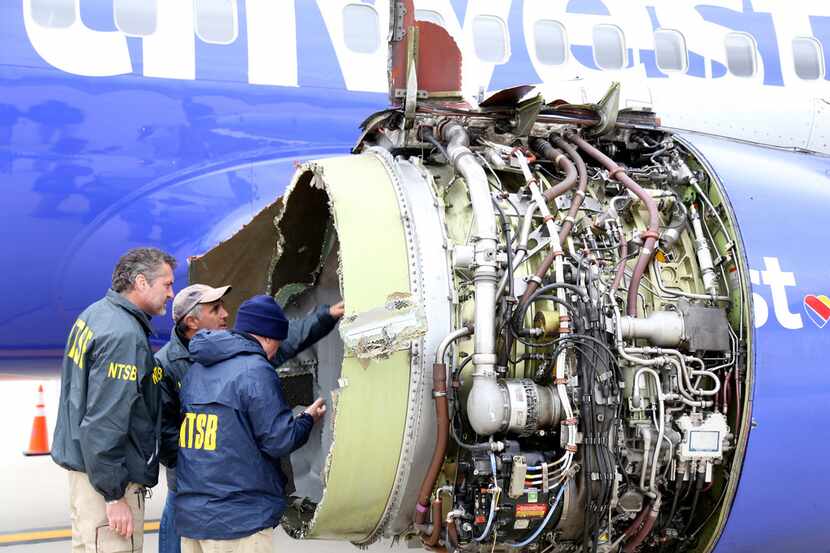 FILE photo shows NTSB investigators examining damage to the engine of the Southwest Airlines...