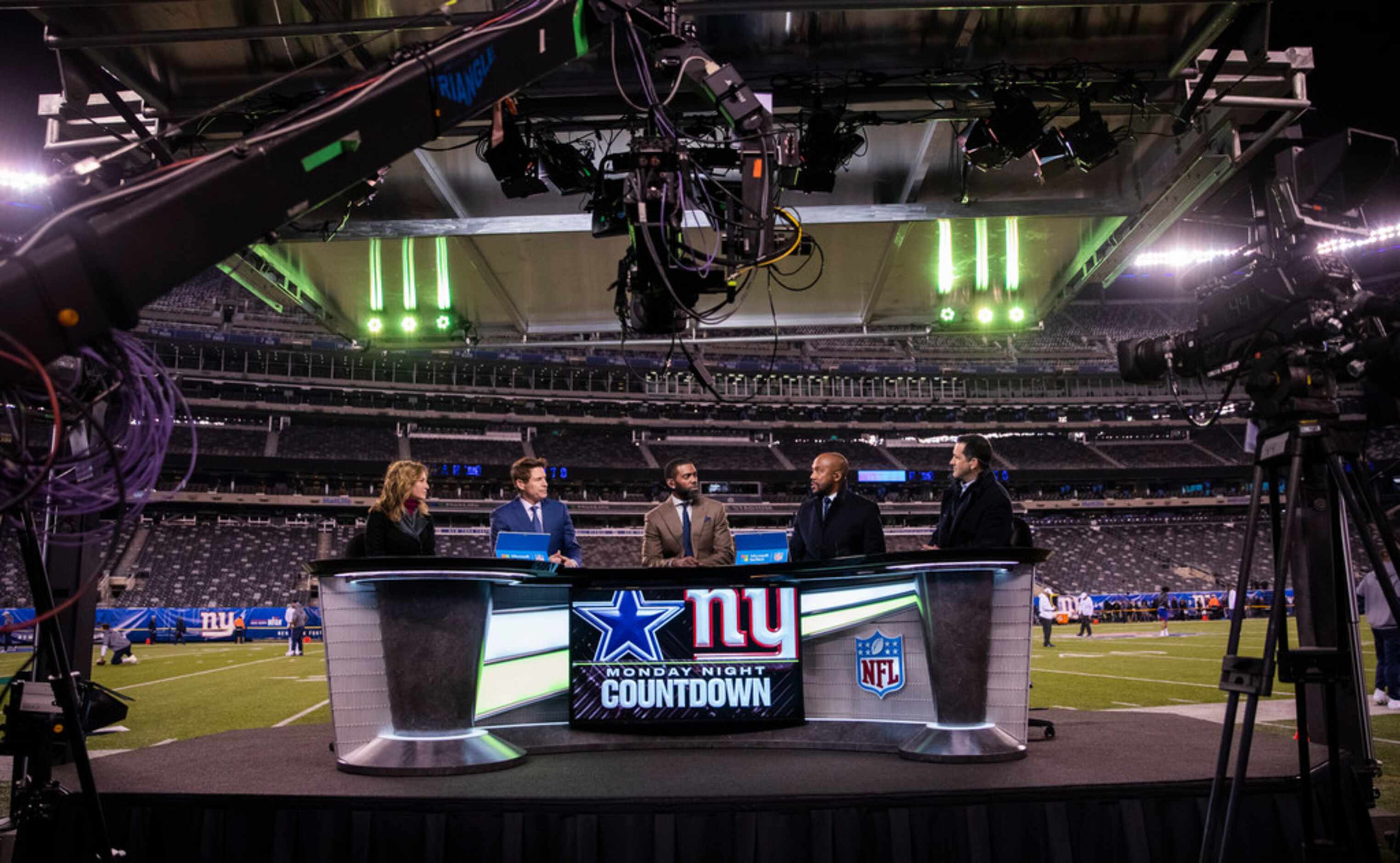 Monday Night Football announcers talk during the pregame show before an NFL game between the...