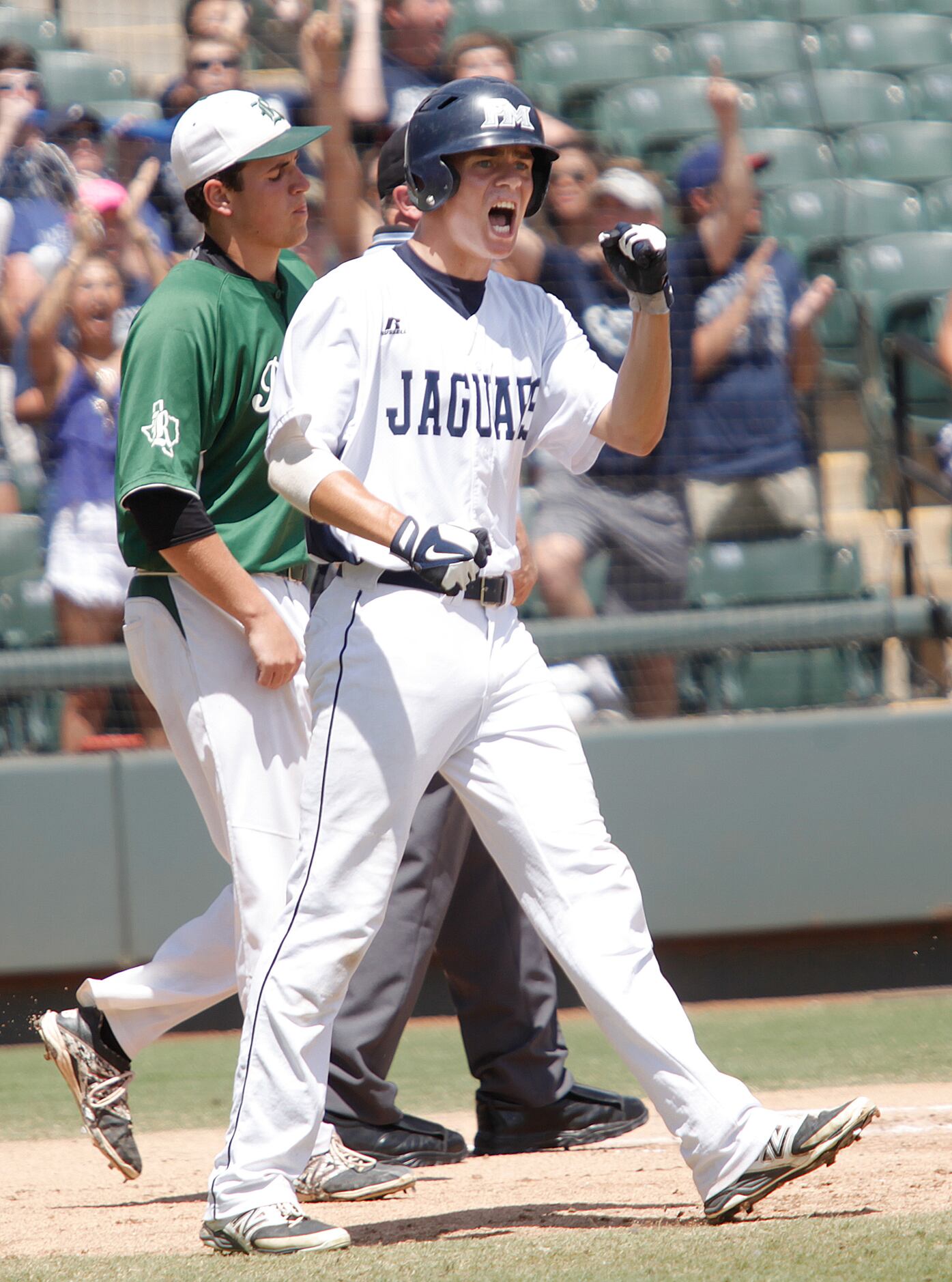 Flower Mound player Connor Wanhanen cheers after he crosses home plate during their game...
