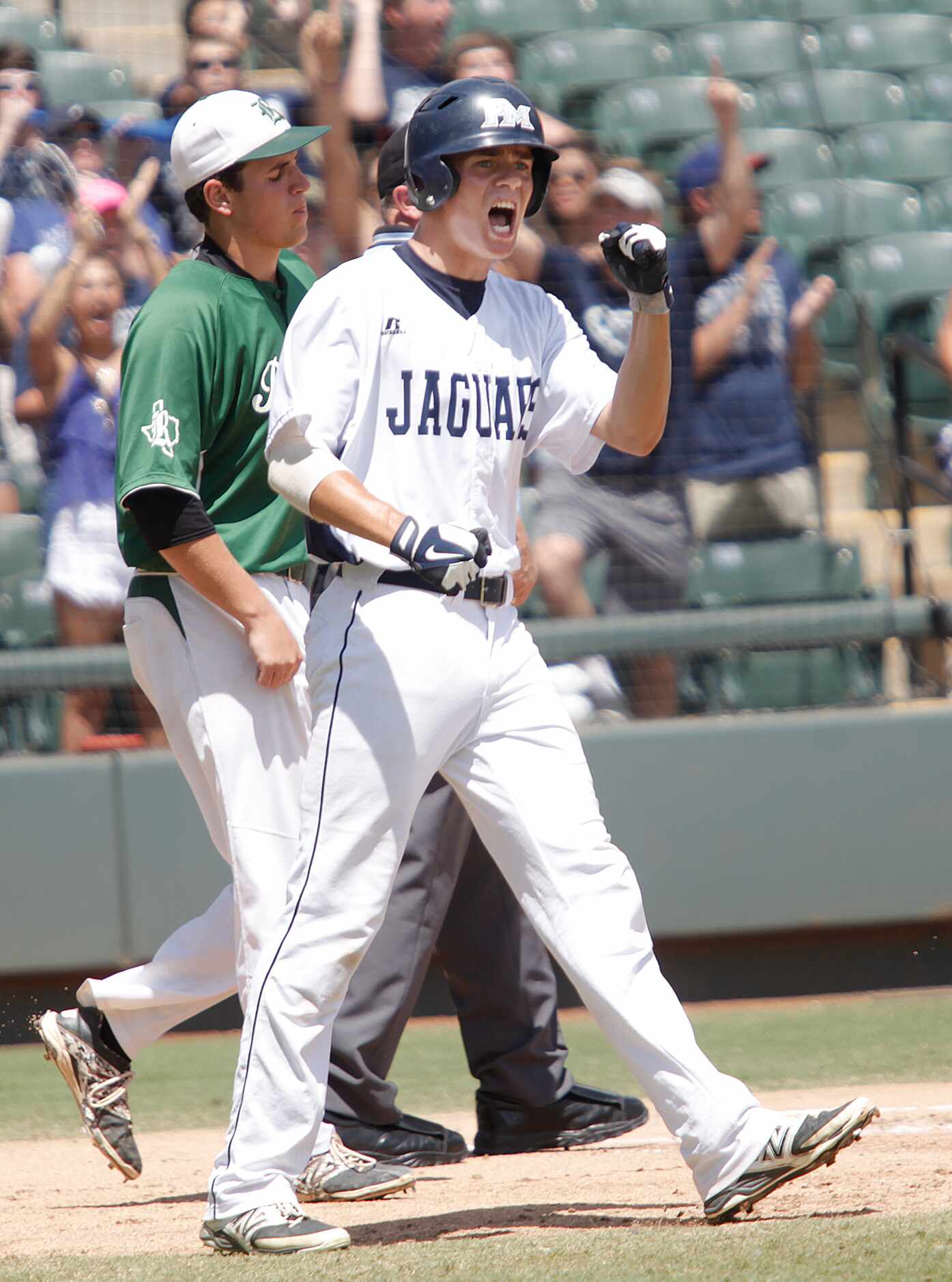 Flower Mound player Connor Wanhanen cheers after he crosses home plate during their game...