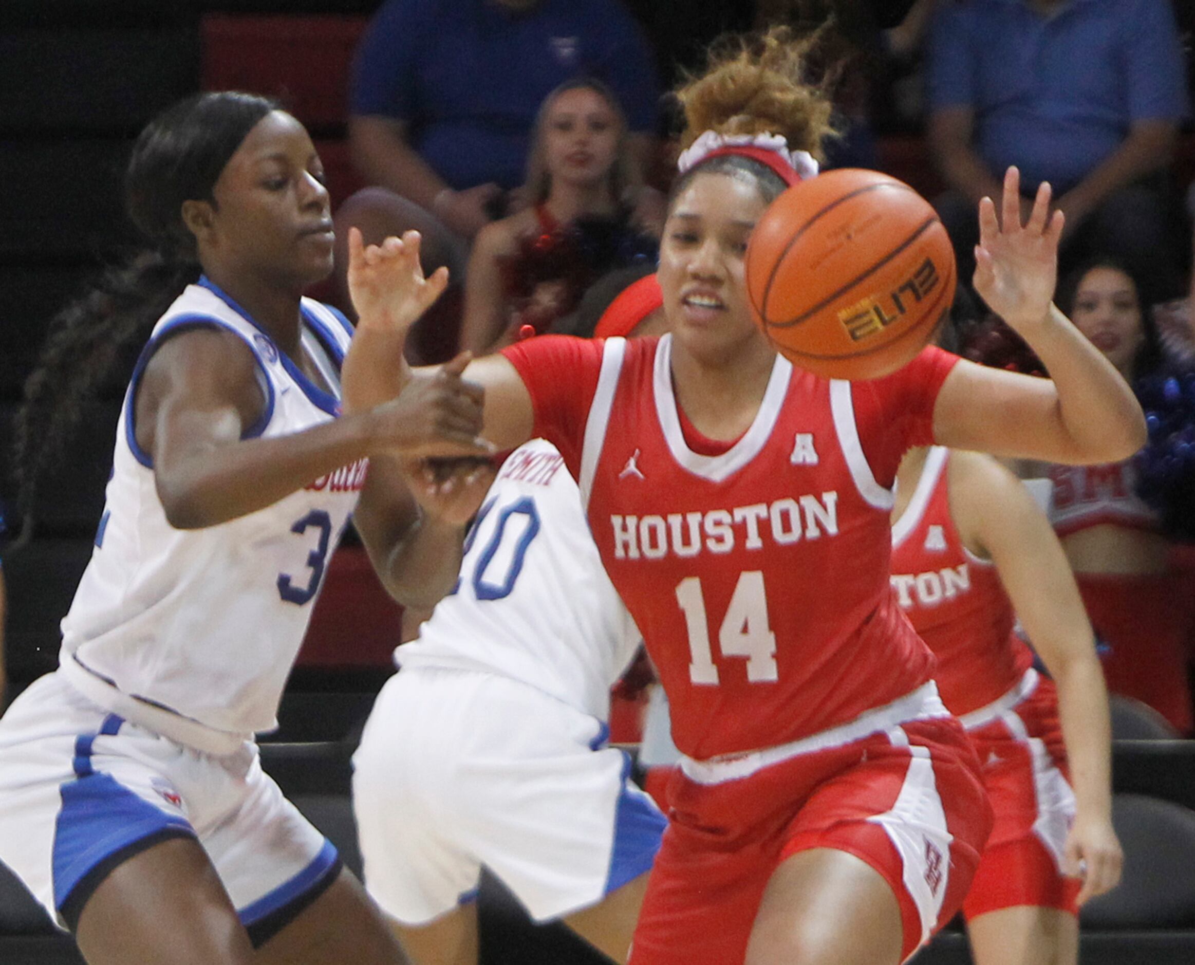 SMU guard Kayla White (32), left, knocks the ball away from Houston guard Laila Blair (14)...