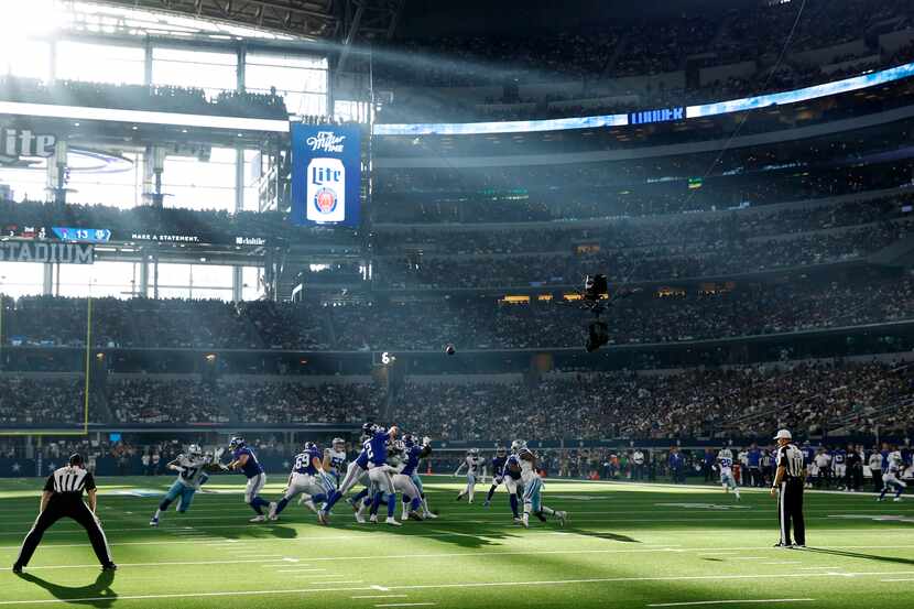 Rayos del sol asoman por un ventanal del AT&T Stadium en el juego de los Cowboys de Dallas...