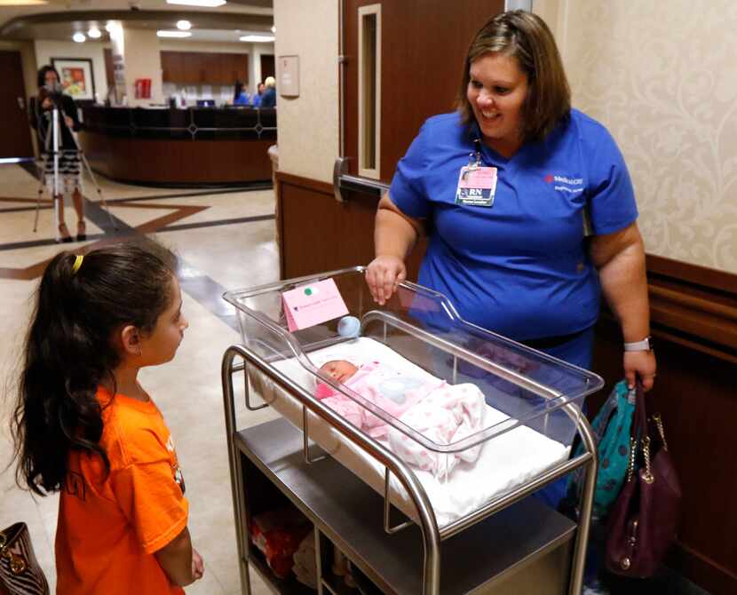 Narale Negrete, 7, watches as RN Colleen McGuire takes her newborn baby sister Ximena back...