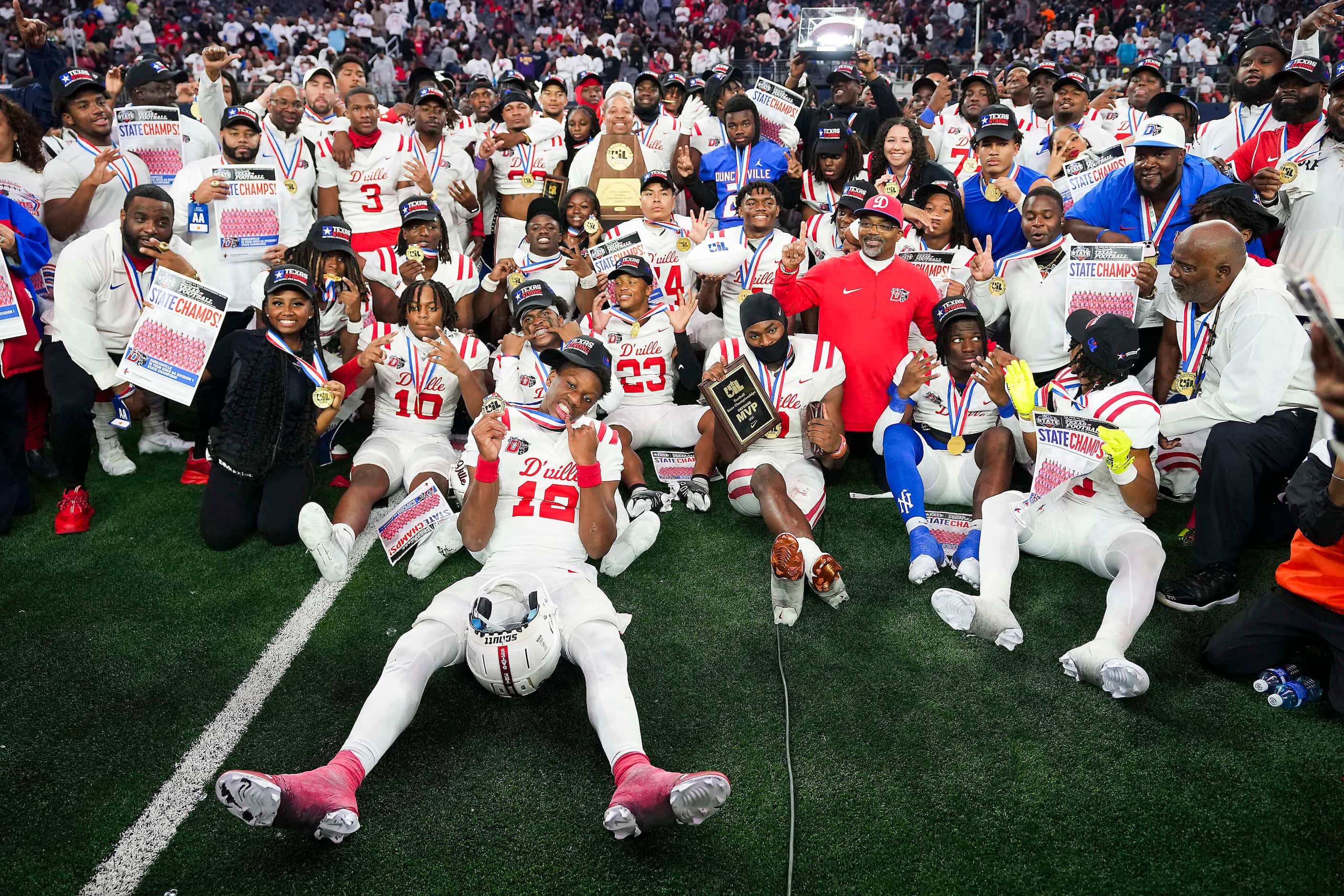 Duncanville players pose for a team photo with the championship trophy after a victory over...