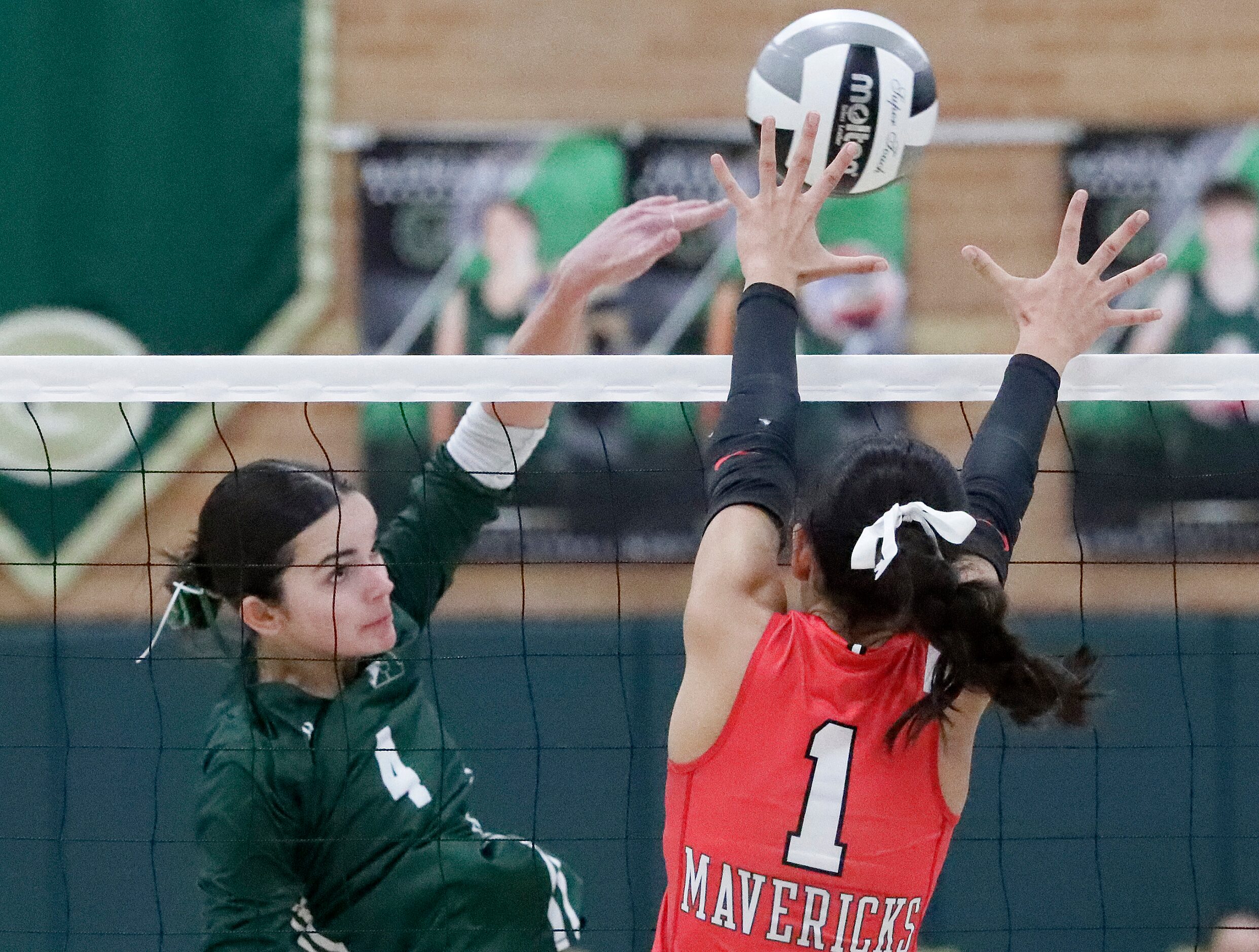 Hockaday setter Campbell Trubey (4) gets a hit past St. John's Kiran Rio (1) during game one...