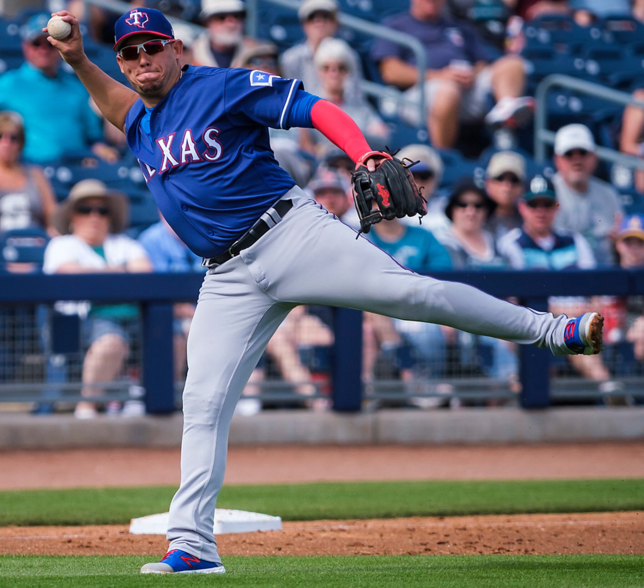 Texas Rangers third baseman Asdrubal Cabrera makes a throw to first after bare-hanging a...