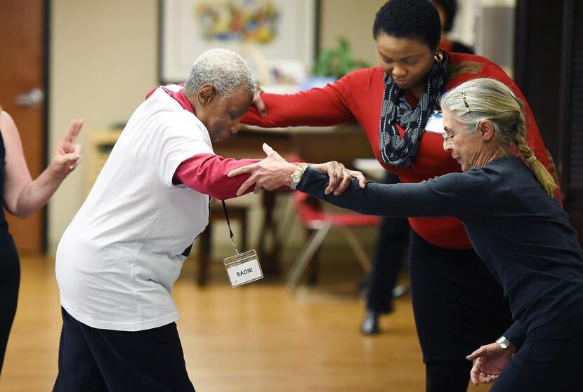 
Sadie Armstrong gets help from Sarah Nwosu and Judy Cooper (right) in a balance class at...
