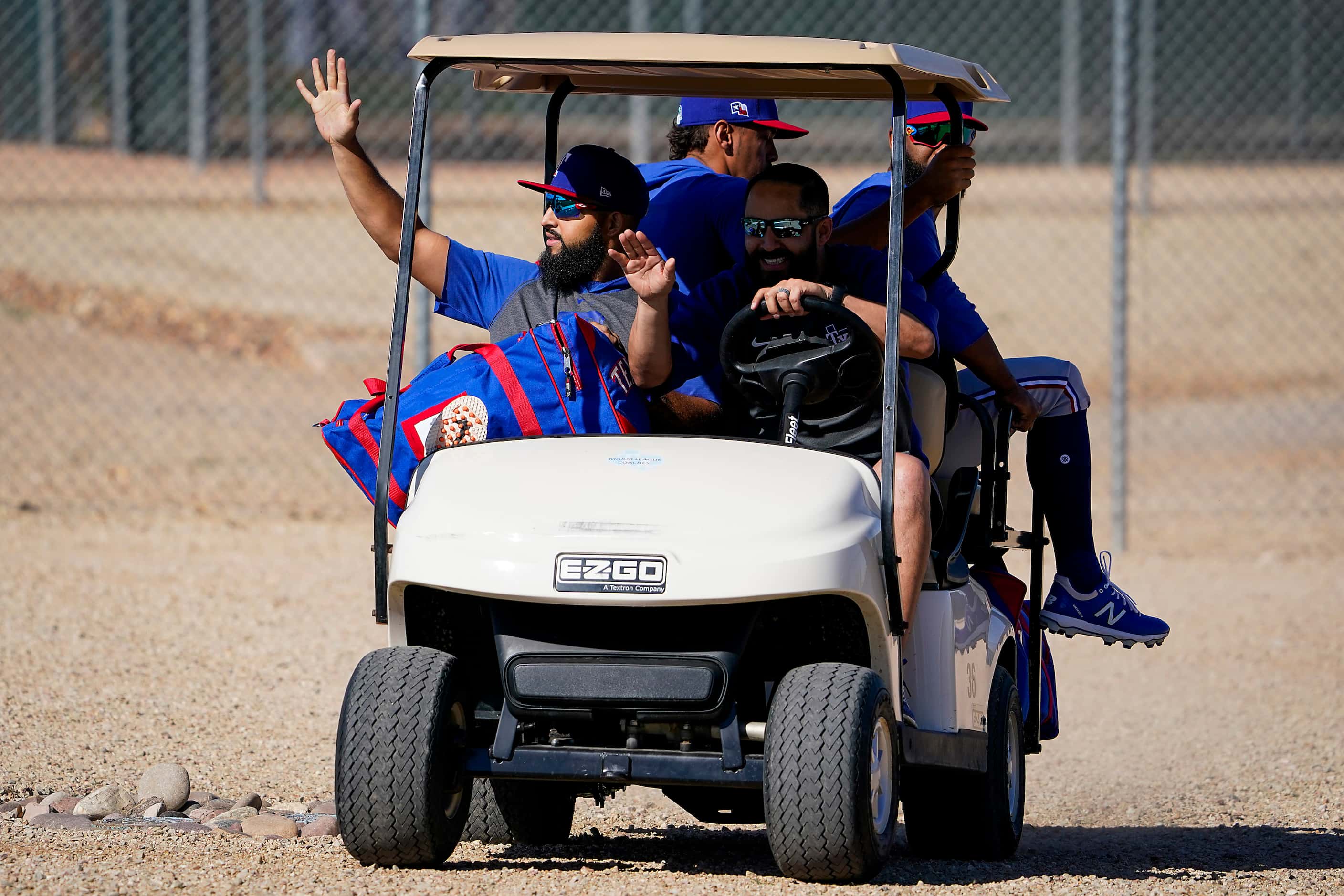 Texas Rangers second baseman Rougned Odor (left) waves to fans as he rides in a golf cart...