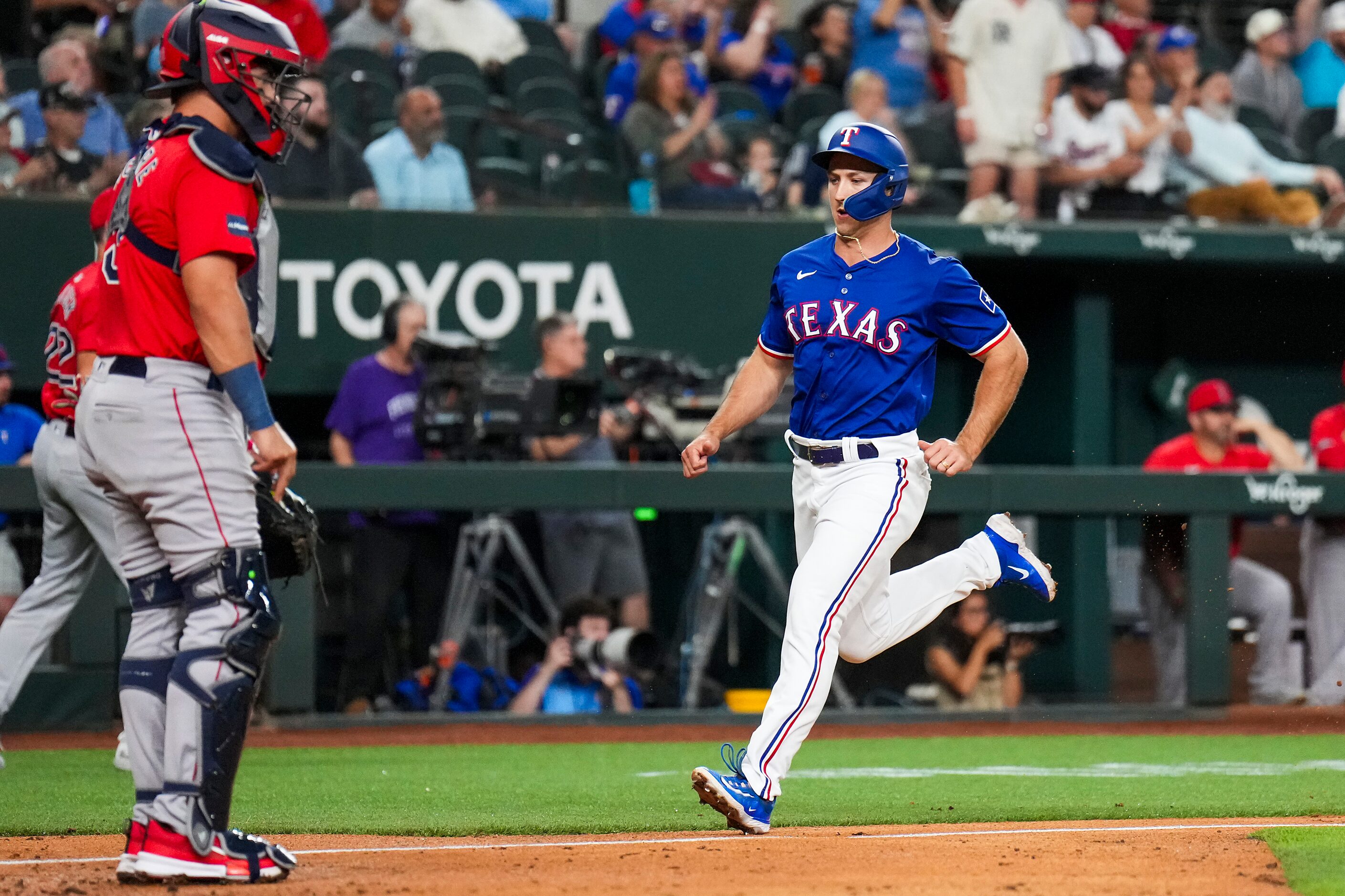 Texas Rangers designated hitter Wyatt Langford scores on a single by infielder Jared Walsh...