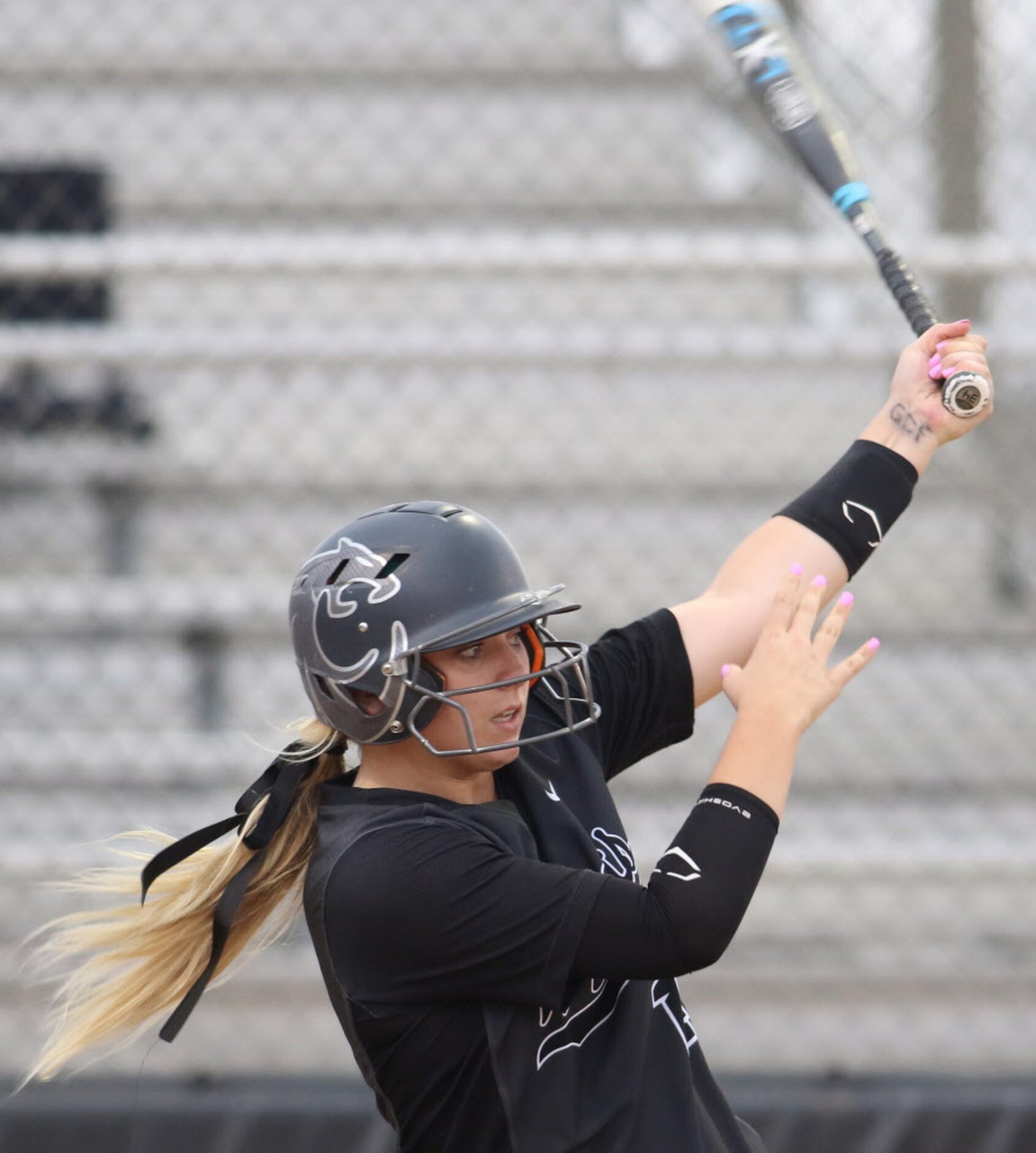 Denton Guyer catcher Maddie Green (14) watches a drive into the outfield as she bats in the...