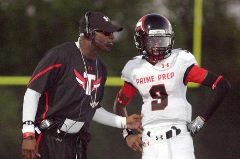 Prime Prep coach Deion Sanders (left) talks with sophomore quarterback Joshua Davis (9) in...