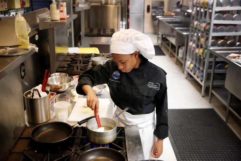 High school junior culinary student Taylor Givens stirs rice pilaf on the stove as she...
