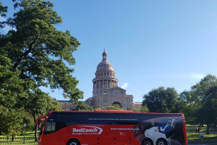 A RedCoach bus sits in front of the Texas State Capitol in Austin.