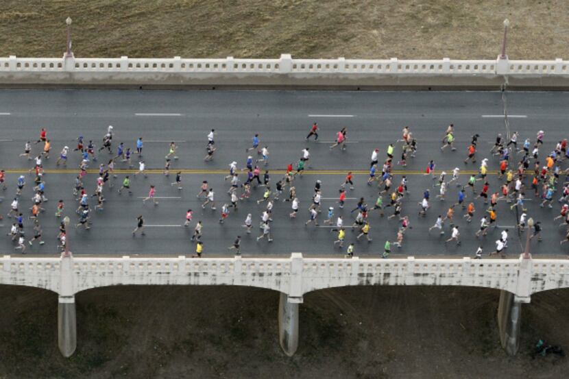 Runners make their way across the Commerce Street bridge during the MetroPCS Dallas Marathon...