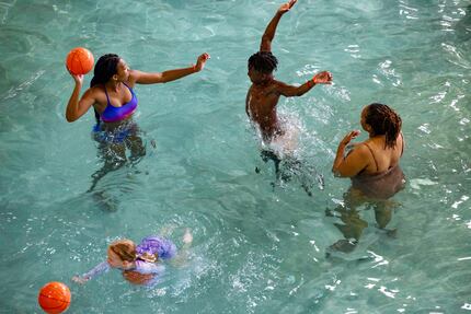 Dominic Brown (center), 11, attempts to block a shot as he celebrates the day before his...