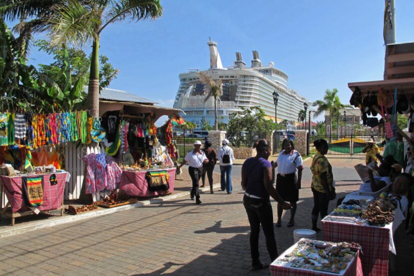 Street vendors sell souvenirs near Royal Caribbean's Allure of the Seas in Falmouth,...