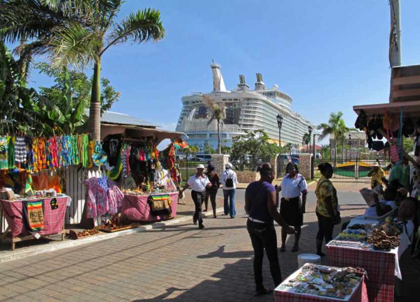 Street vendors sell souvenirs near Royal Caribbean's Allure of the Seas in Falmouth,...