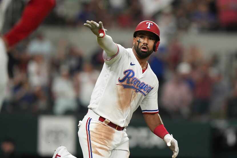 Texas Rangers Ezequiel Duran gestures towards his dugout after hitting a solo home run...