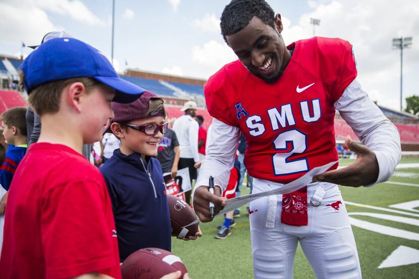 Southern Methodist Mustangs wide receiver Deion Sanders Jr. (2) signs autographs for Aiden...