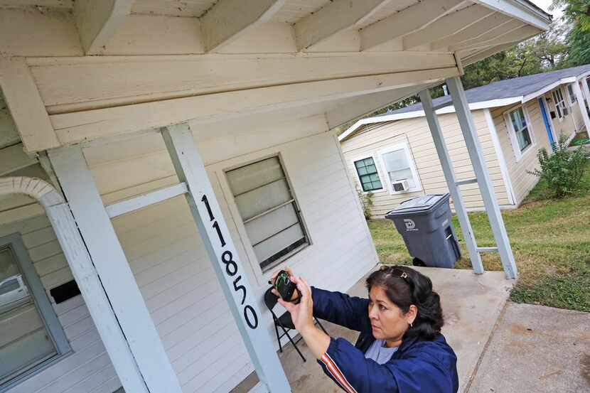 City of Dallas code inspector Diana Conde takes a photo of a repair that was done to the...