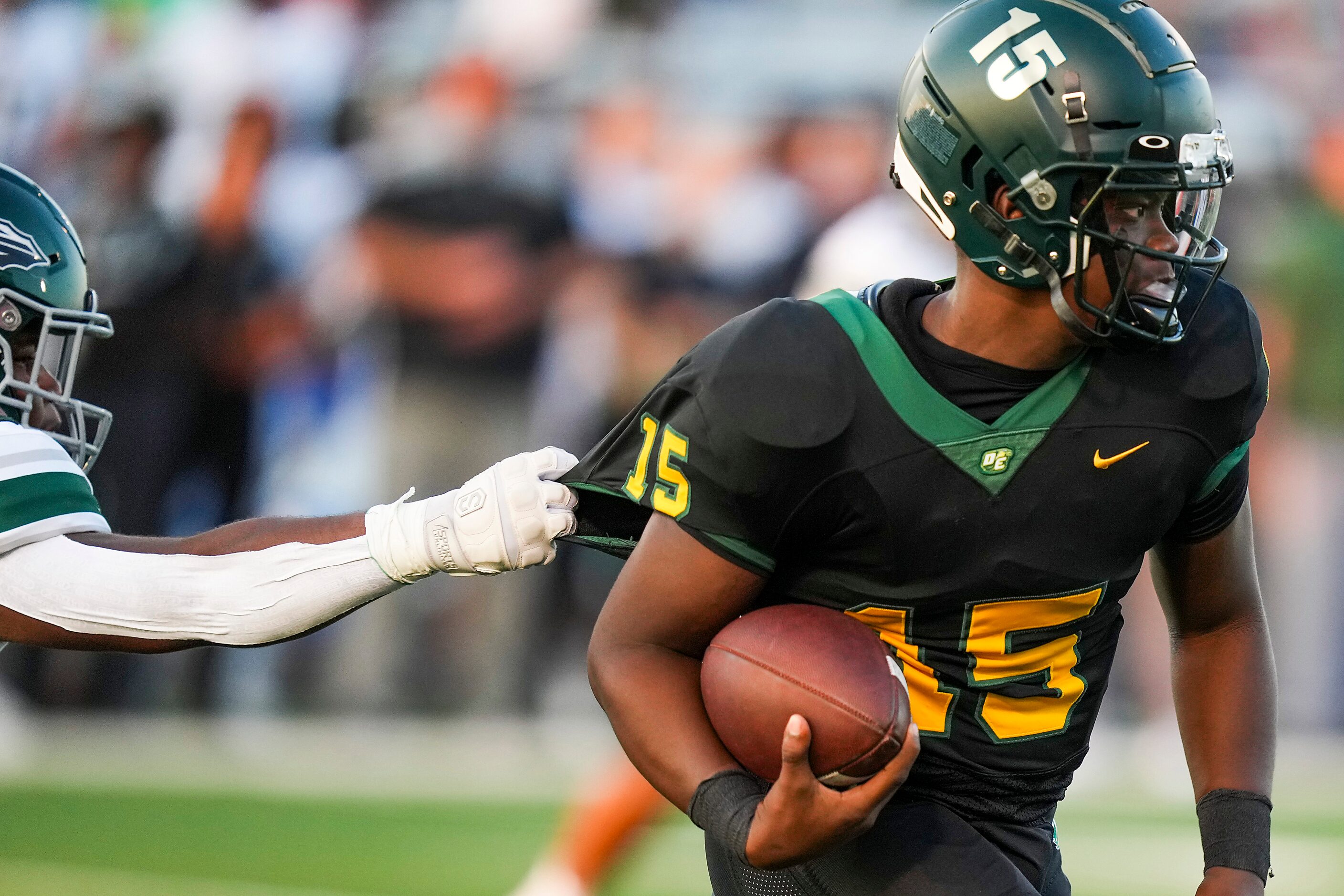 DeSoto quarterback Darius Bailey (15) slips away from Waxahachie defensive tackle Jacob...