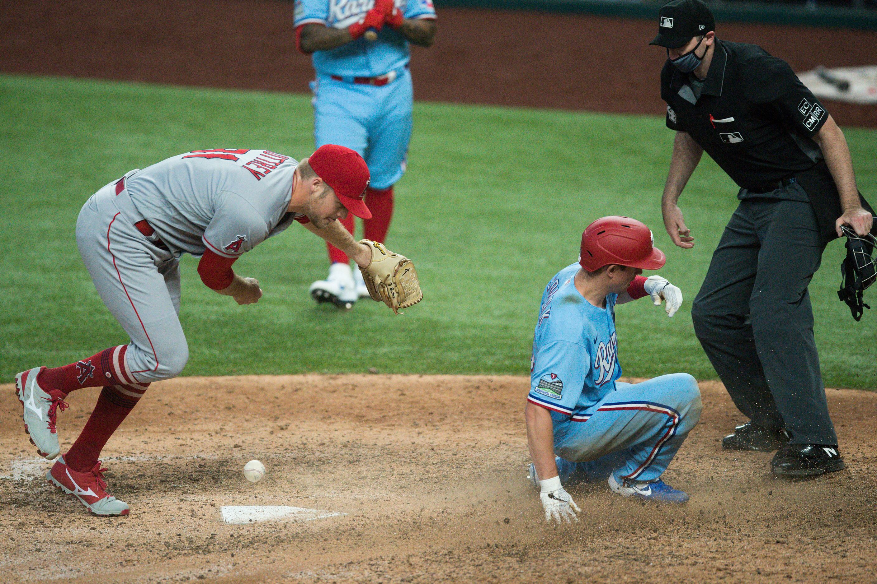 Texas Rangers outfielder Nick Solak scores on a wild pitch past Los Angeles Angels relief...