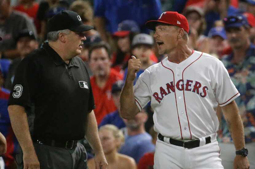Texas Rangers manager Jeff Banister (28) talks with first base umpire Stu Scheurwater after...