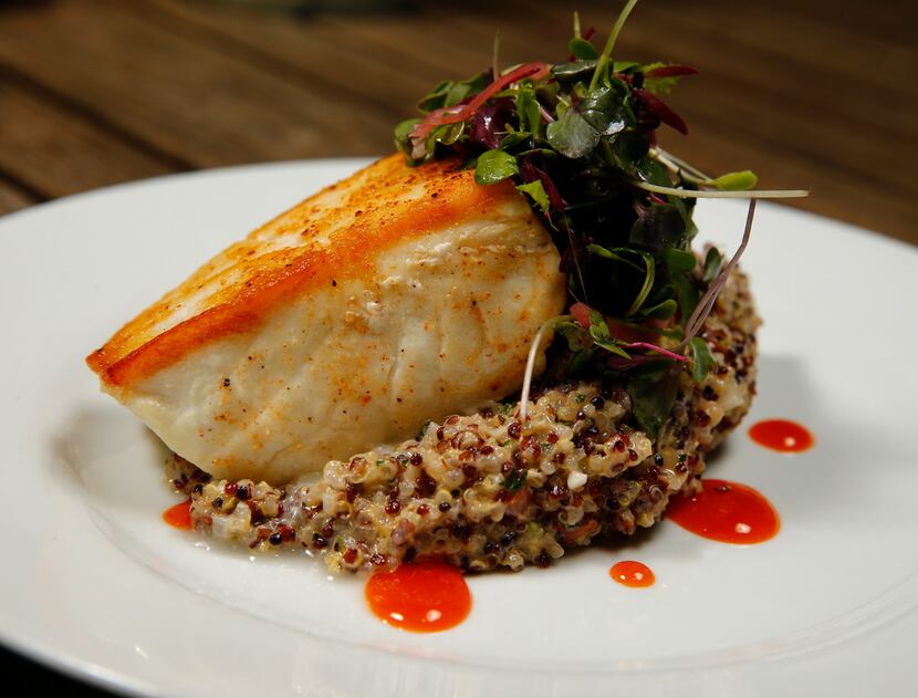 Pan-roasted halibut is presented on a bed of creamy quinoa risotto.