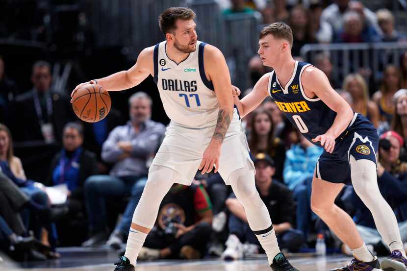 Dallas Mavericks guard Luka Doncic, left, looks to pass the ball as Denver Nuggets guard...