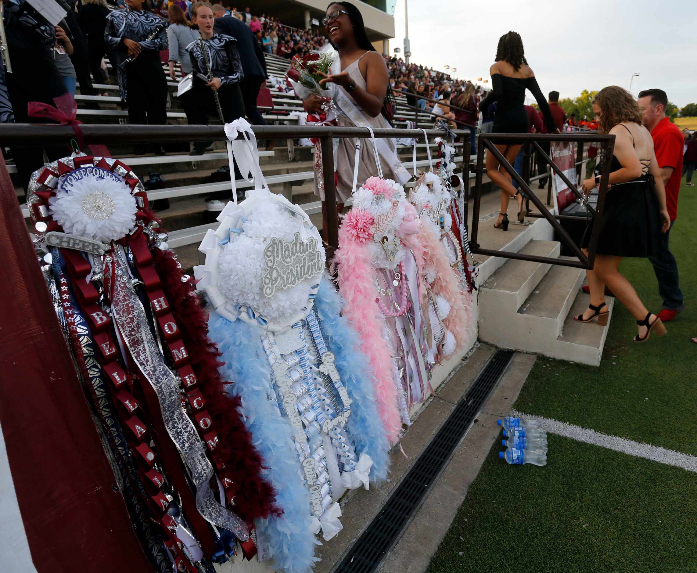 The homecoming court heads to the stands, as mum hang on a railing before the start of the...