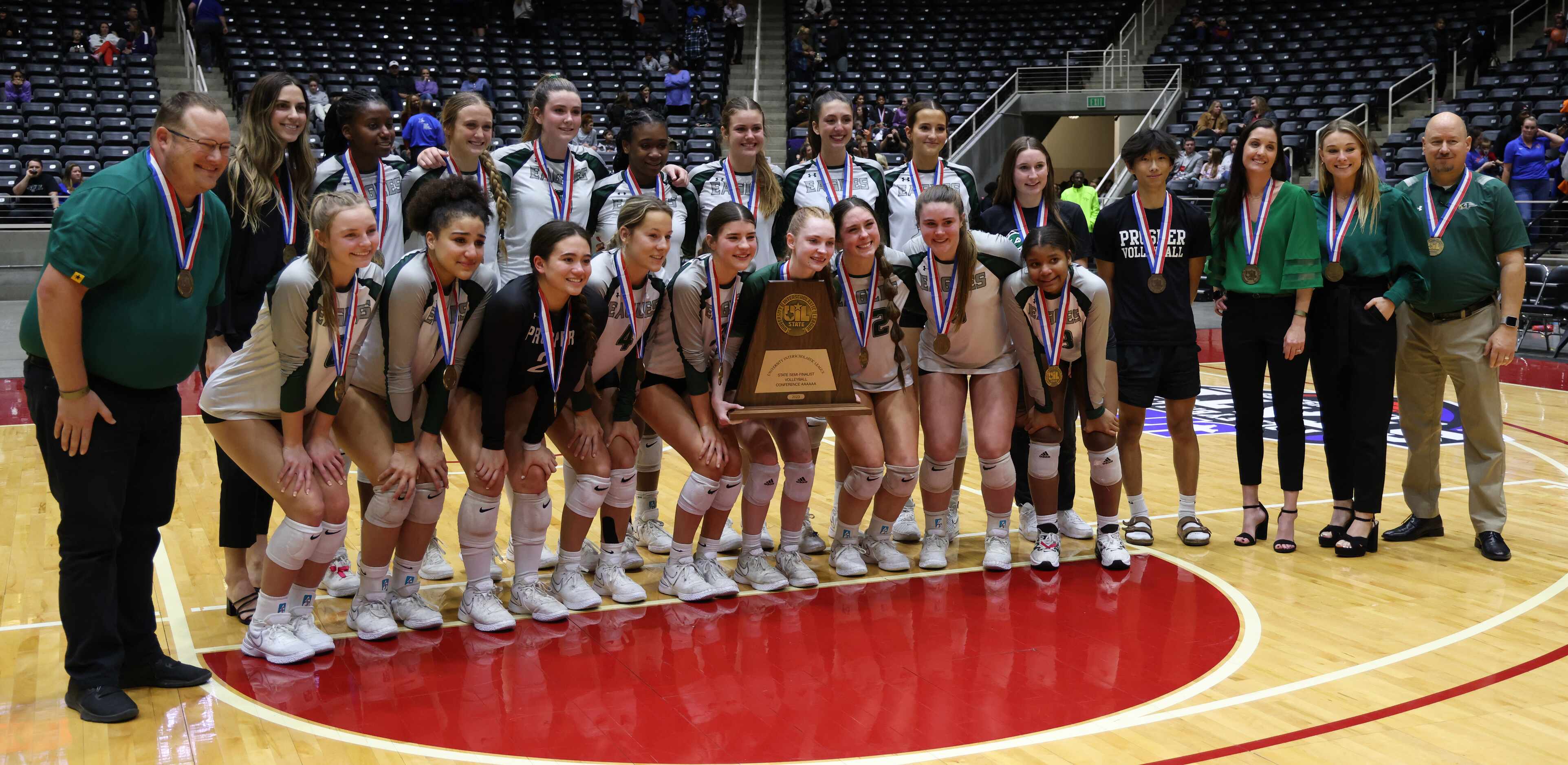 Prosper players and coaches pose with the Class 6A state semi-finalist trophy after their...
