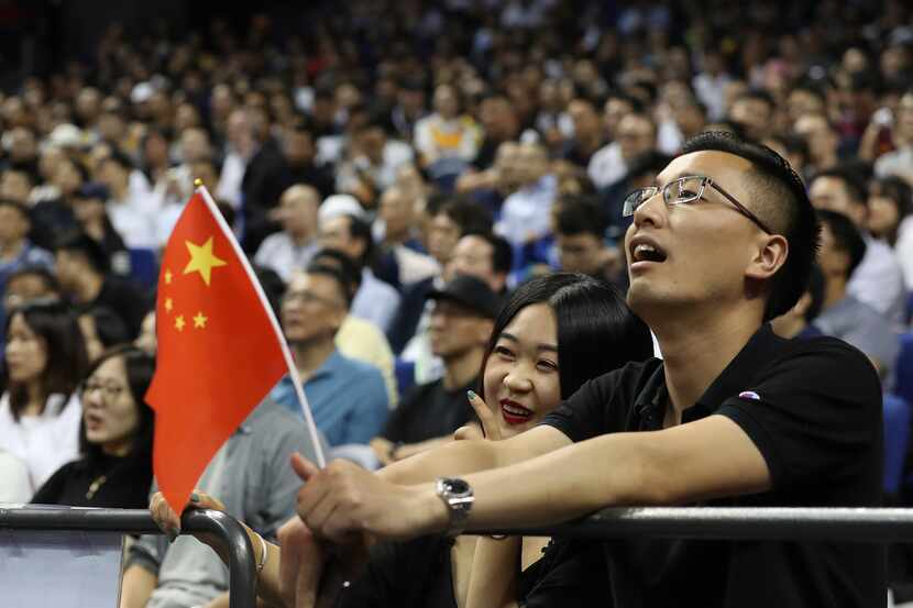 Chinese fans with a Chinese flag watch a preseason NBA basketball game between the Brooklyn...