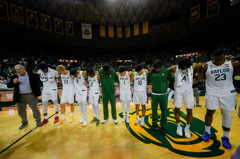 Baylor players gather for a prayer at the end of an NCAA college basketball game against...