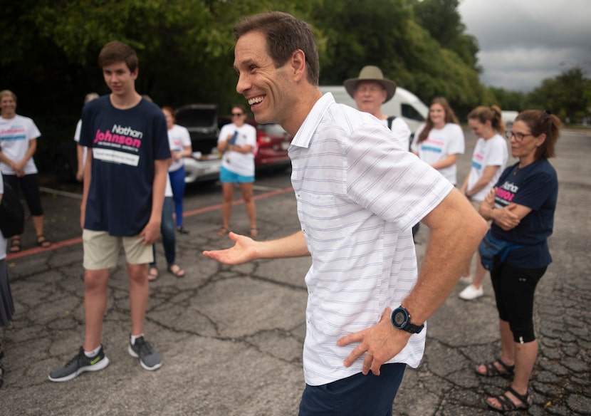 Nathan Johnson talks with volunteers before they set out to canvass a neighborhood during...