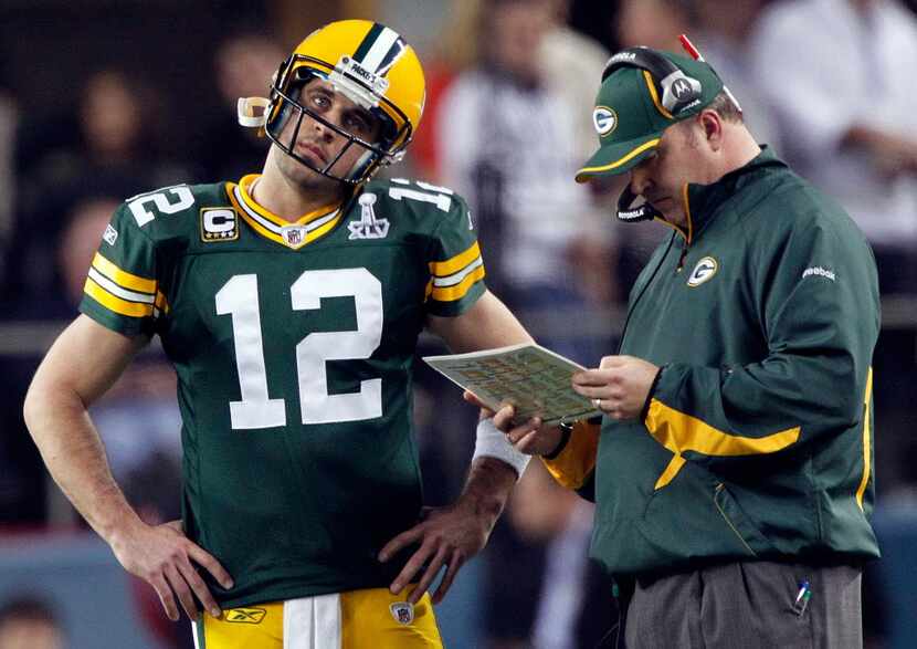 FILE — Green Bay Packers quarterback Aaron Rodgers listens to head coach Mike McCarthy in...