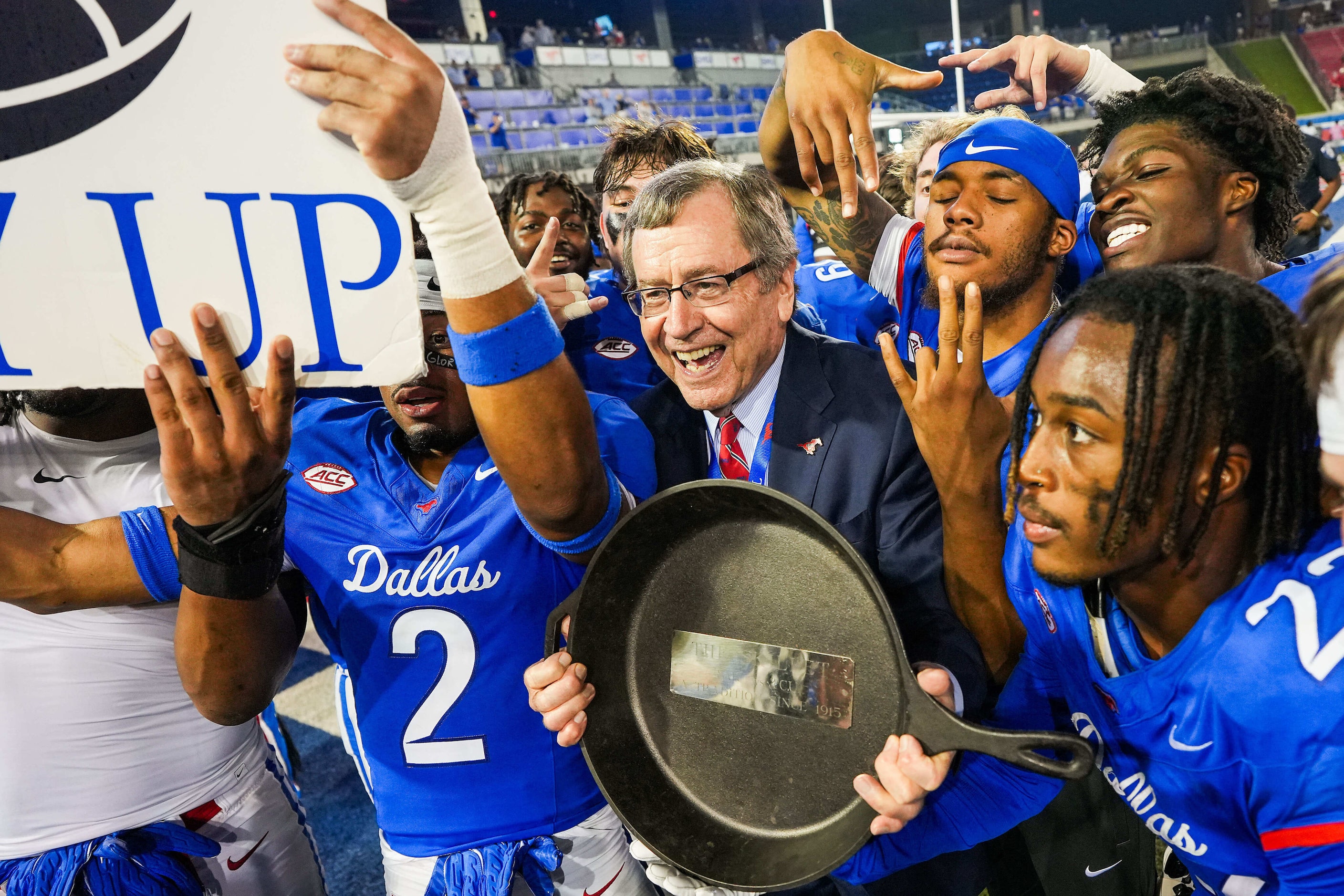 SMU President R. Gerald Turner holds the Iron Skillet trophy as the Mustangs celebrate after...