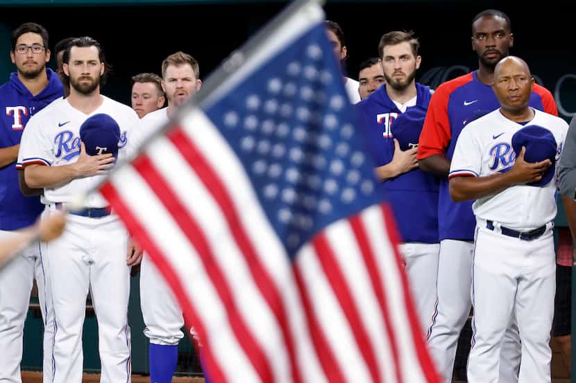 Texas Rangers players and coaches stand for the national anthem during the Texas Rangers...