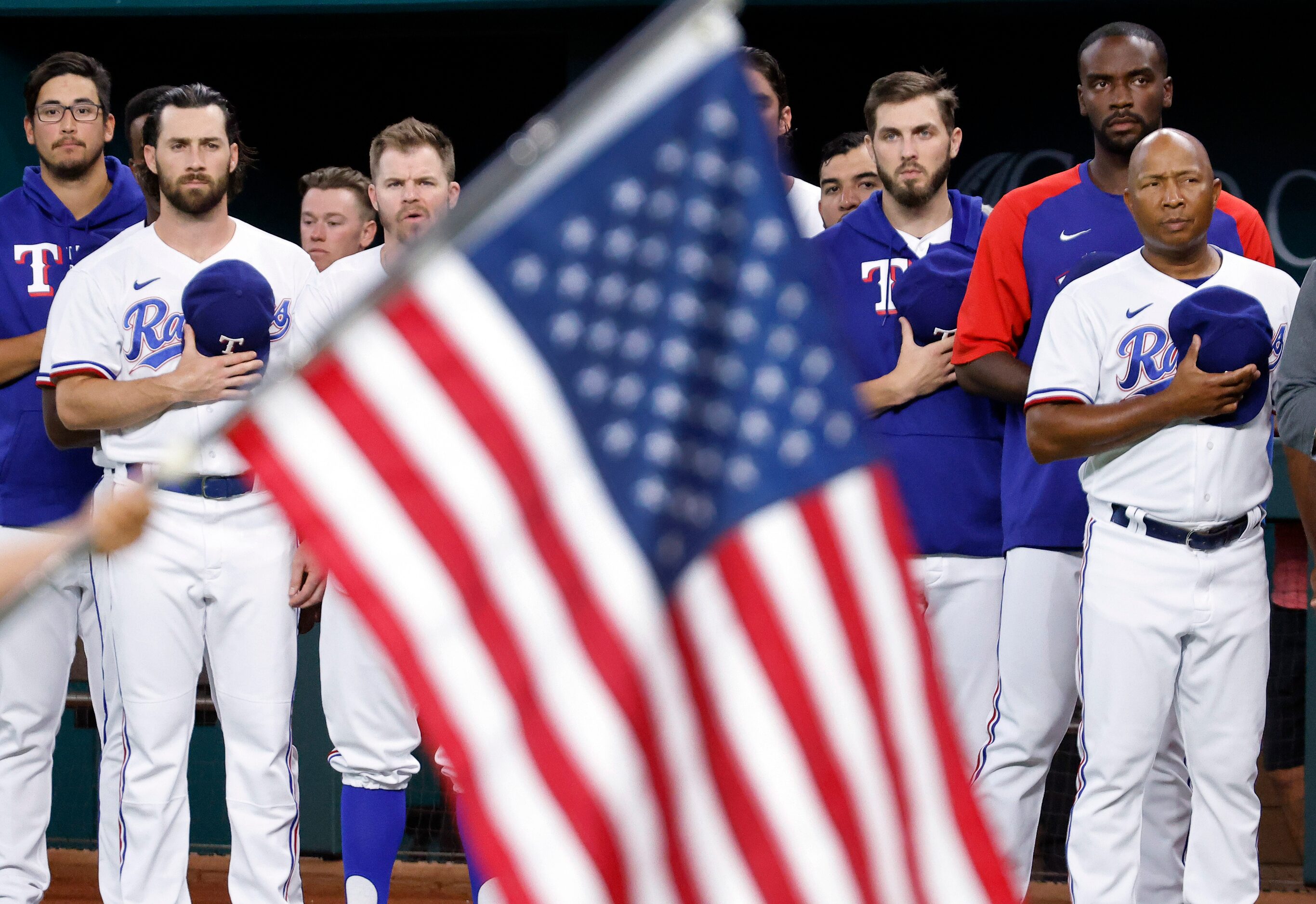 Texas Rangers players and coaches stand for the national anthem during the Texas Rangers...