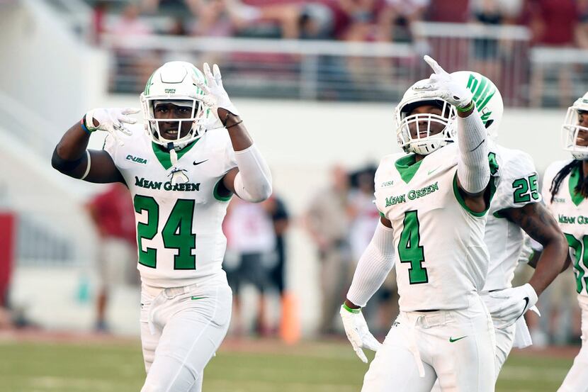 North Texas defender's Taylor Robinson (24) and Khairi Muhammad (4) celebrate after...
