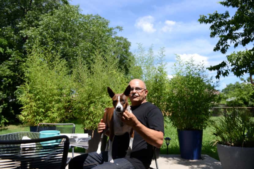 Robert Munez sits on his patio with his dog Neylah located in a Farmers Branch neighborhood,...