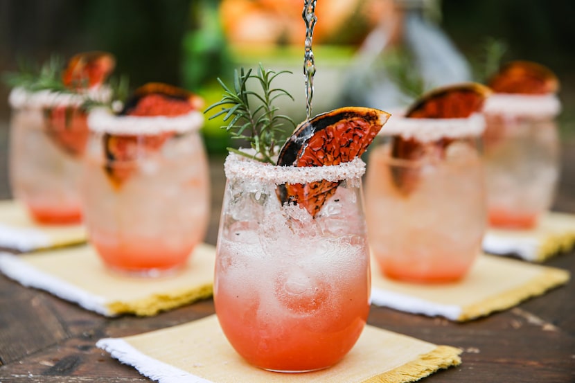 Texas Greyhound, in a rocks glass, rimmed with pink sea salt, garnished with broiled...