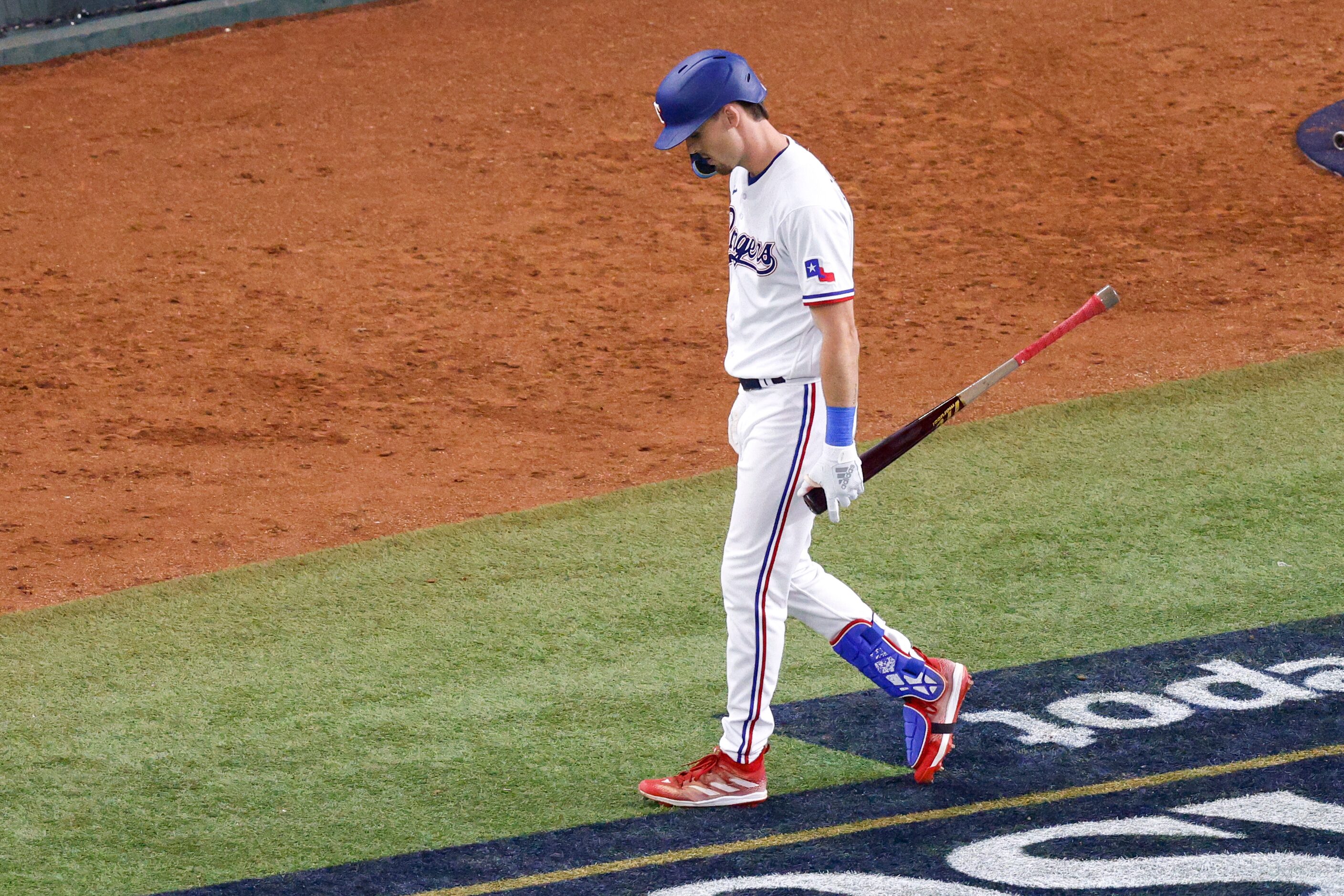 Texas Rangers left fielder Evan Carter (32) walks to the dugout after striking out to end...